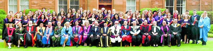 CELEBRATION . . . the graduates line up with university staff as they show off their degrees