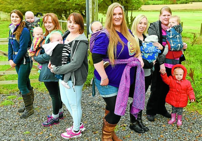 SLING SUPPORTERS . . . mums and their tots met in Lockerbie yesterday to mark International Babywearing Week. They gathered for a walk at Eskrigg Nature Reserve all wearing their children in slings. Left to right: Jasmine and Archie, Lauren and Bridgette, Kerrie and Rubie, organiser Emma Dinnin of the Slinging Around group and Ralph, Nadine and Harris and Gail with Coen and Lauryn. Anyone wishing to find out more is invited to go to the Slinging Around Dumfries and Galloway Facebook page