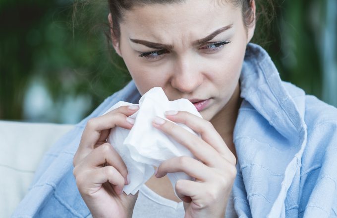 Ill woman blowing nose