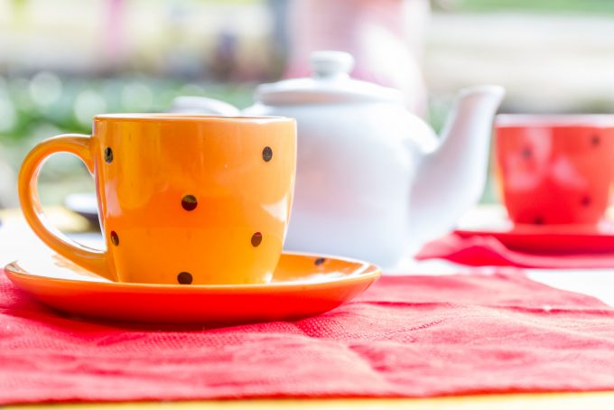 two bright tea cups set for breakfast in outdoor cafe