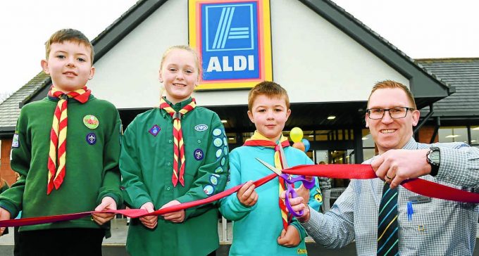 OPEN FOR BUSINESS . . . Aldi Annan’s manager Lee Richardson was joined by Annan Scouts Jenna Pearson, Aidan Swallow and Alex McGlasson to officially open the new store yesterday 