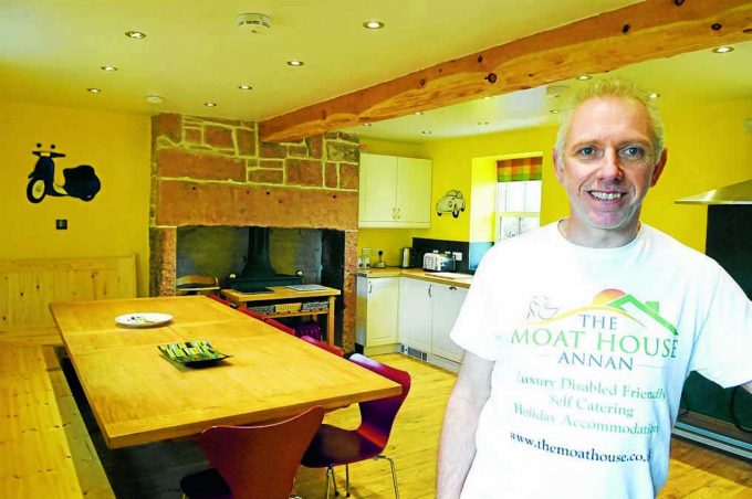 SPACIOUS KITCHEN. . . Martin Storer shows off the large farmhouse kitchen created in Moat House *** Local Caption *** SPACIOUS KITCHEN. . . Martin Storer shows off the large farmhouse kitchen created in Moat House
