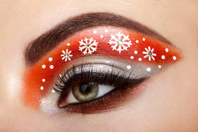 Eye girl makeover snowflakes. Winter christmas makeup. Beauty fashion. Eyelashes. Cosmetic Eyeshadow. Makeup detail. Creative woman holiday make-up