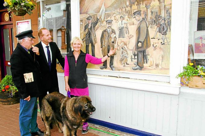 LOOKING BACK . . . artist Jo McSkimming explains the old railway picture to Mark Jardine from the peoples project, centre, and Louis Wall from the South West Railway Adopters Gardening Group at Dumfries Railway Station on Wednesday