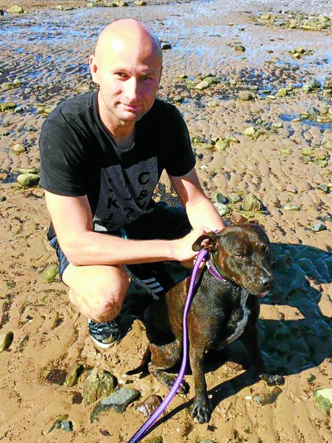 SELFLESS ACT . . . Blazej Reczko, manager of the Steamboat Inn, with Kia the Staffordshire Bull Terrier who he saved from drowning